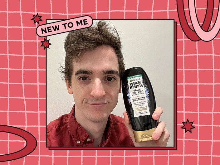 stephen holding up the Garnier Whole Blends Black Charcoal and Nigella Flower Oil Conditioner