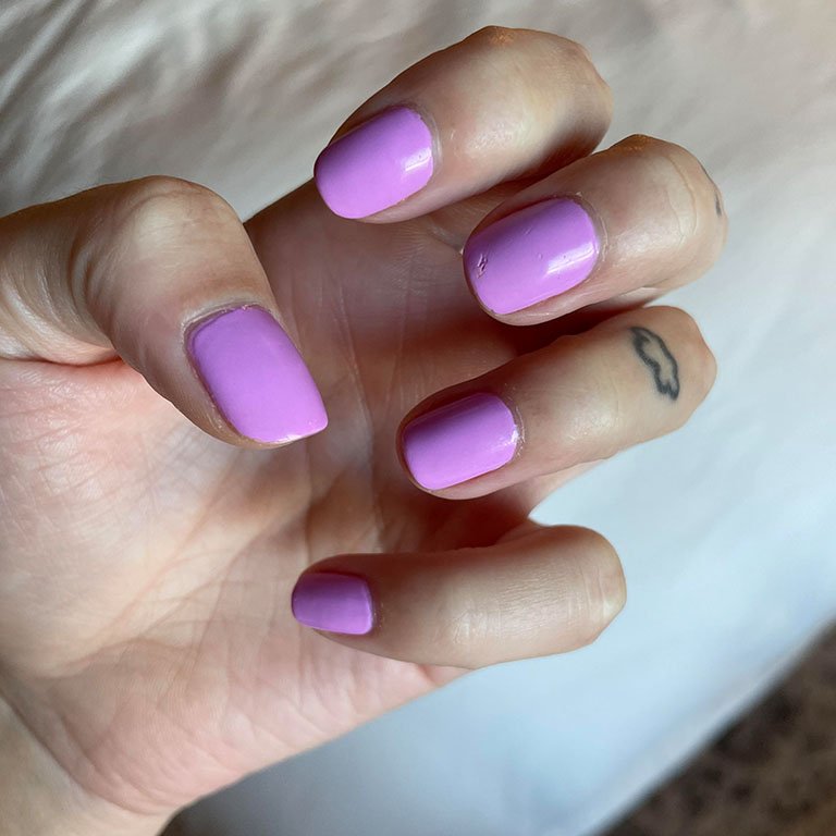 Photo of editor's hand with pink-purple nails