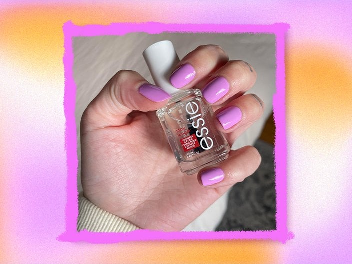 Photo of the editor's hand with pink-purple painted nails holding the Essie Stay Longer Longwear Top Coat collaged on an orange and pink tie-dye background