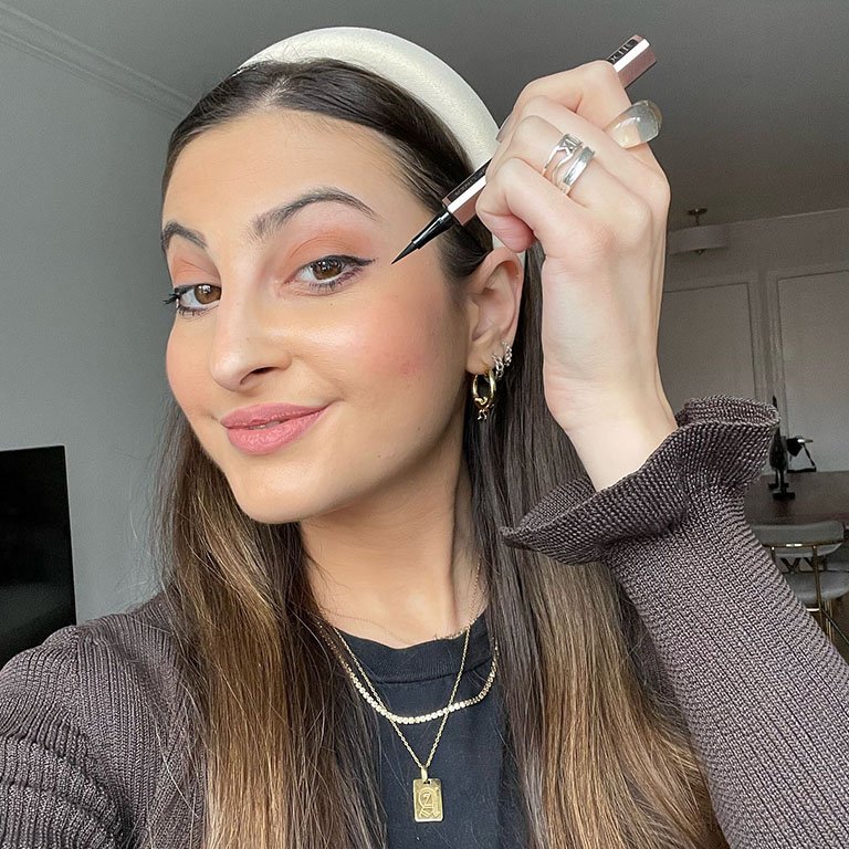 Alanna wearing and holding up the Lancôme Idôle Liner in Glossy Black