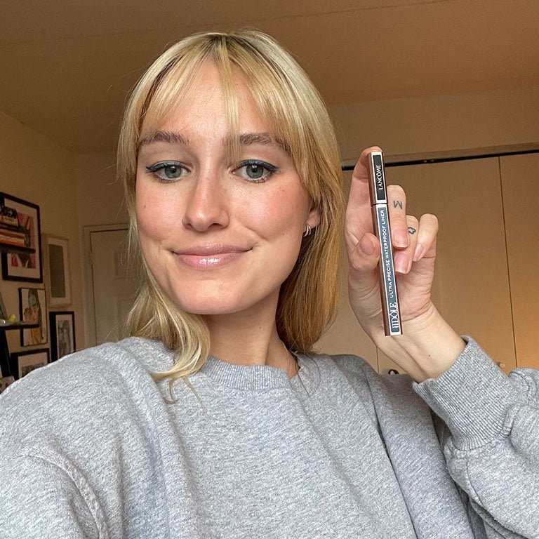 Jordan wearing and holding up the Lancôme Idôle Liner in Aegean Blue