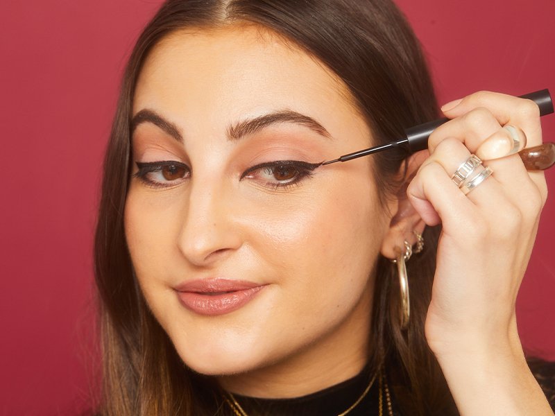Picture of a person drawing on a wing with black liquid liner