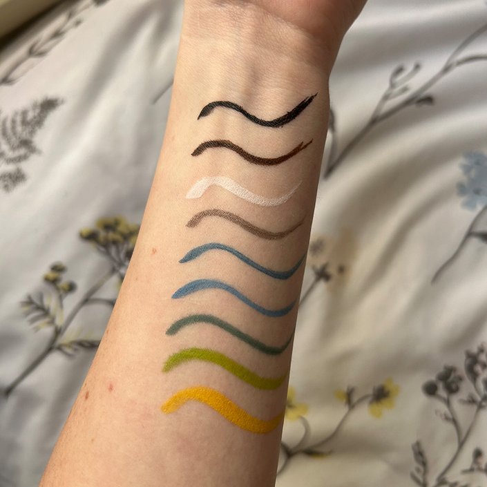 Image of colorful Urban Decay 24/7 Inks Liquid Eyeliners swatched on arm.
