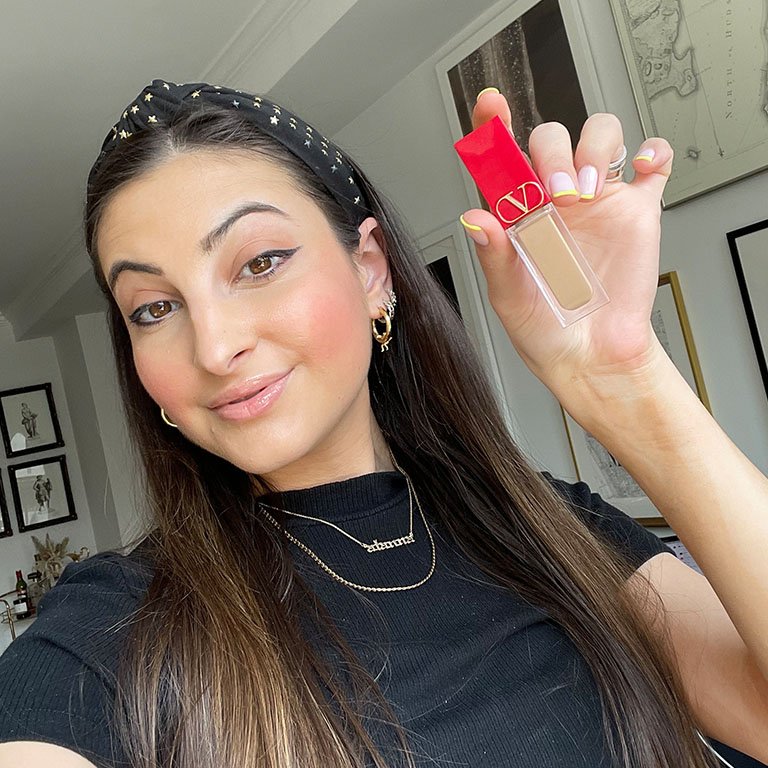 alanna wearing and holding the valentino beauty concealer