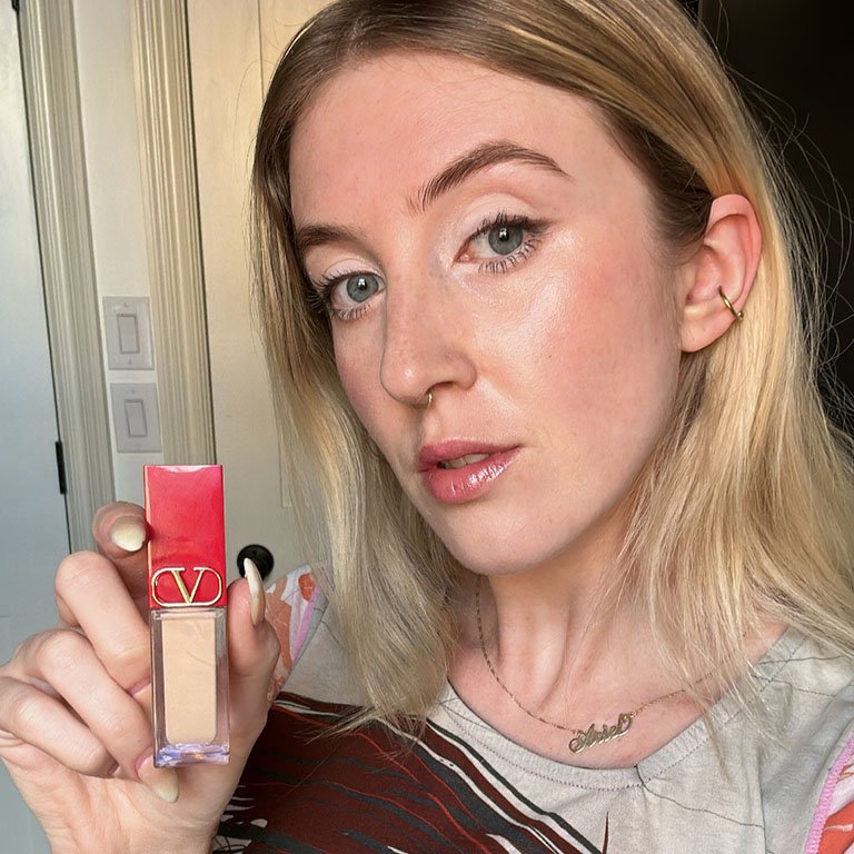 ariel wearing and holding the valentino beauty concealer