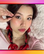 Picture of a person wearing douyin makeup and pigtail braids with red ribbon on a multicolored graphic background