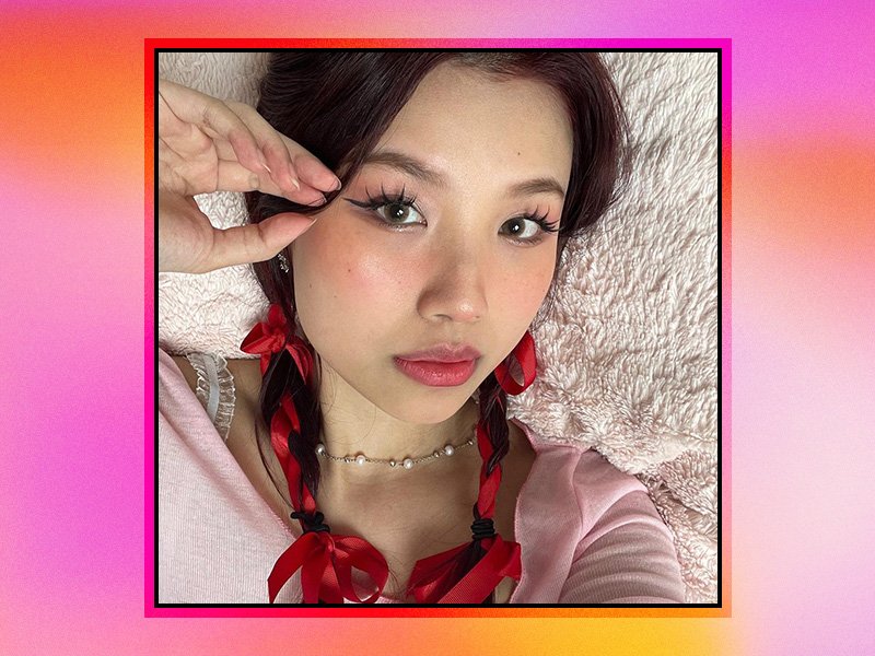 Picture of a person wearing douyin makeup and pigtail braids with red ribbon on a multicolored graphic background