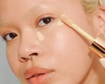 Close-up of a person applying concealer to their under-eye area