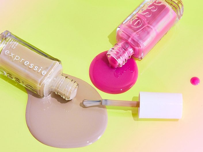 Aerial photo of pink and nude Essie nail polishes spilling over onto a lime green surface