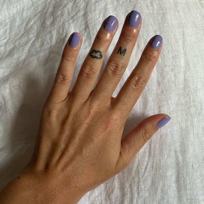 A hand painted with purple nail polish