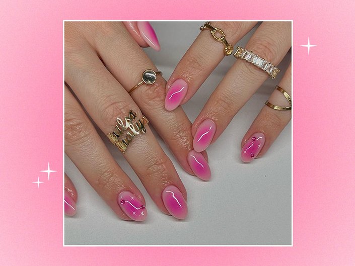 Picture of a person with gold rings and pink blush nails on a pink gradient background
