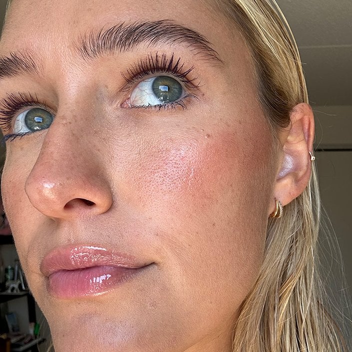 Close-up of the editor wearing purple and blue mascara, looking up