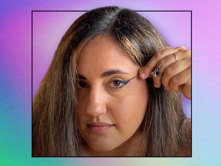 Photo of a person with long dark hair using a bobby pin to trace a cat eye with eyeliner, collaged on a purple and green tie-dye background