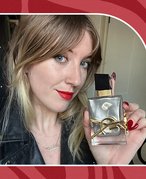 Photo of the editor holding the YSL Beauty Libre Absolu Platine on a swirly red graphic background