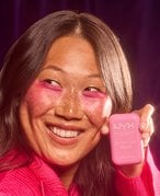 Smiling woman holding Nyx Makeup