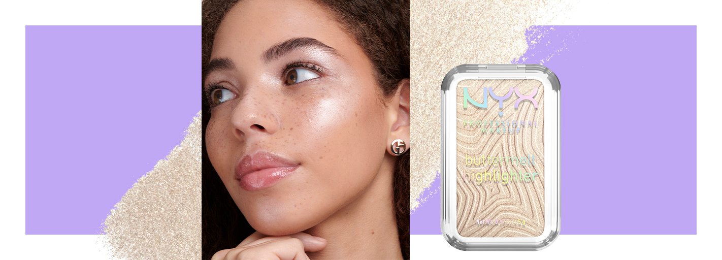 Close-up of a person in profile looking to the side of the camera with their hair pulled back and three dots of highlighter on their cheeks not blended in