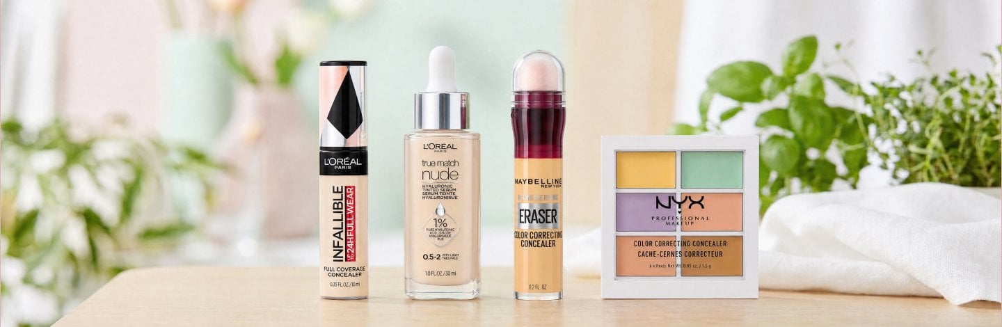 Image of a lineup of color correcting makeup products and concealers positioned on a table. Products are: L'Oréal Paris Infallible Full Wear Concealer up to 24H Full Coverage, L'Oréal Paris True Match Nude Hyaluronic Tinted Serum, NYX Cosmetics 3C Color Correcting Concealer Palette, Maybelline Instant Age Rewind® Eraser Color Correcting Concealer.