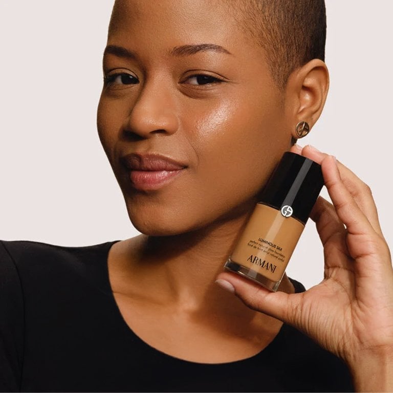 Woman holding a bottle of Giorgio Armani Beauty Luminous Silk Foundation