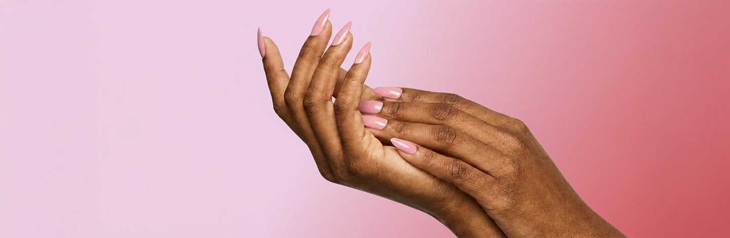A close-up shot of perfectly-manicured hands with nail polish painted on the nails.
