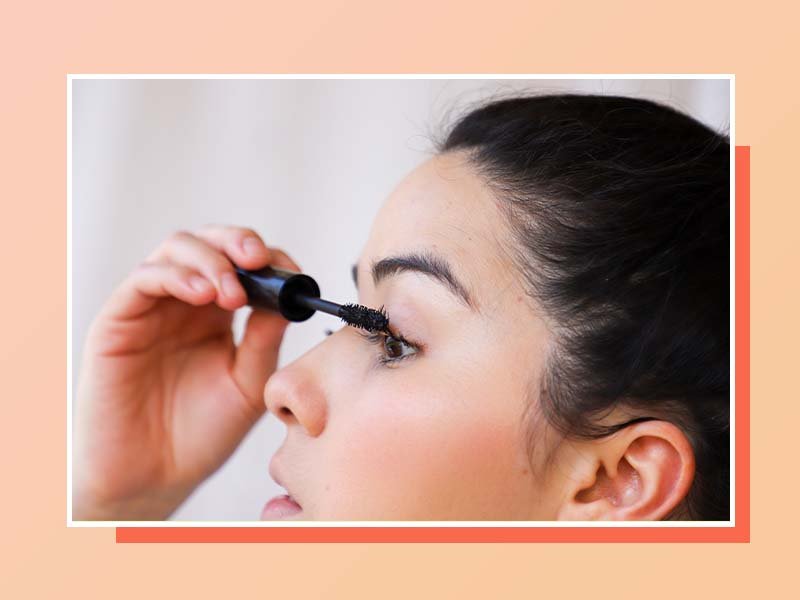 person applying mascara to eyelashes